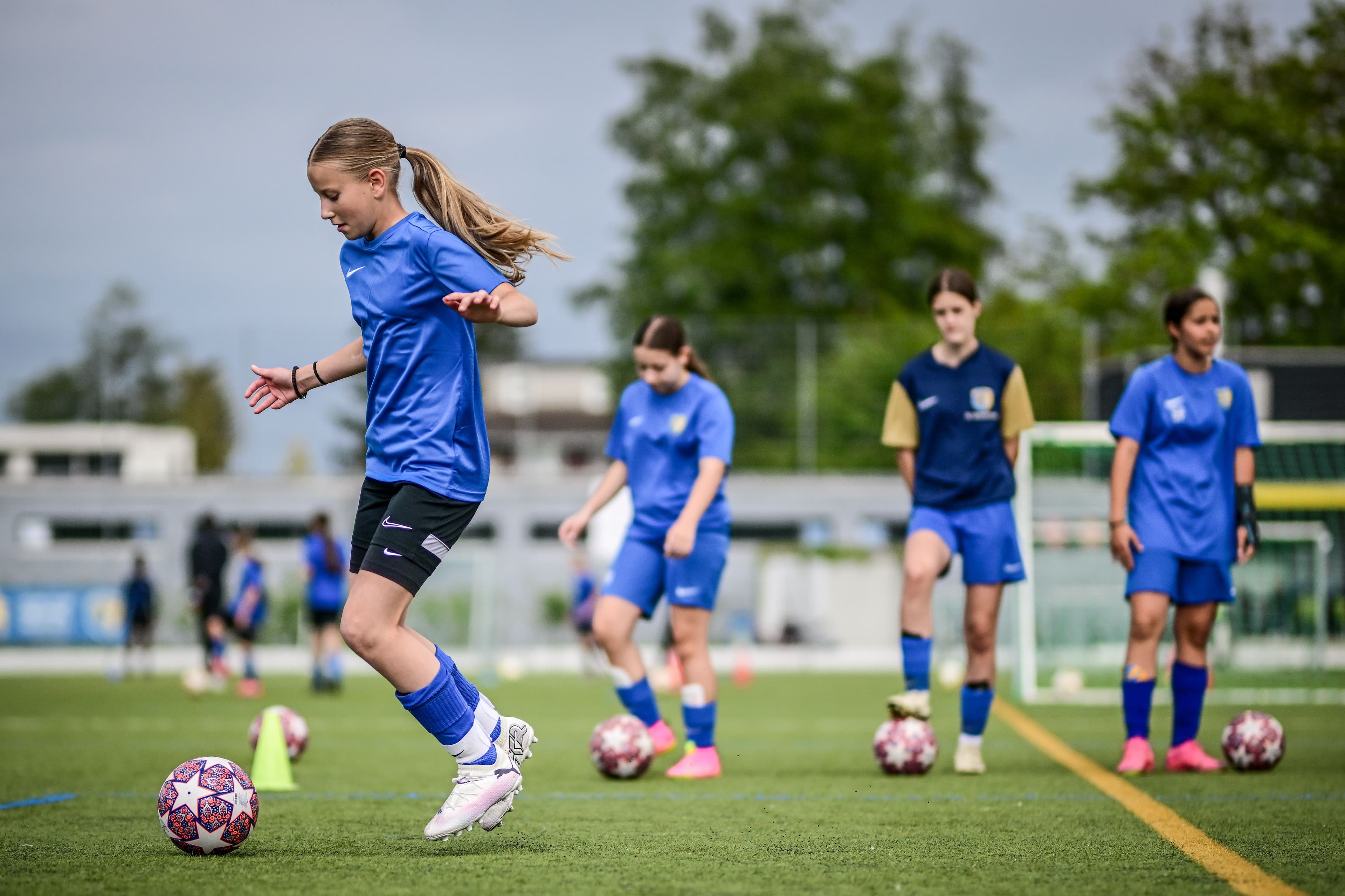 Mädchen in blauen Trikots im Training auf dem Fussballplatz